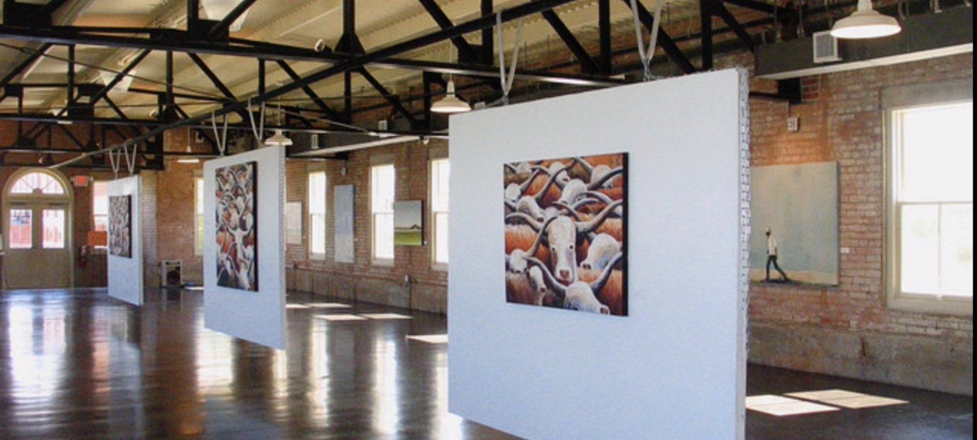 The Filter Building interior, exposed brick and iron trusses, hung for an exhibition